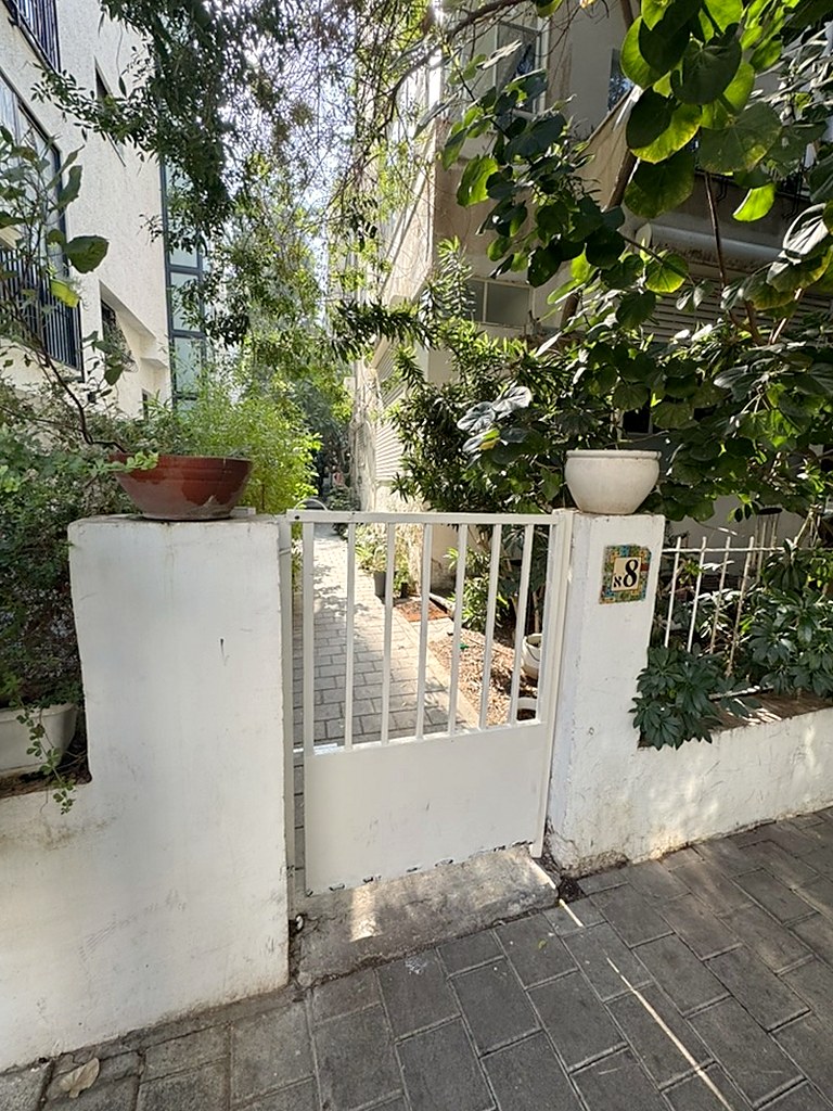 הכניסה: השער הלבן עם השלט 8א.